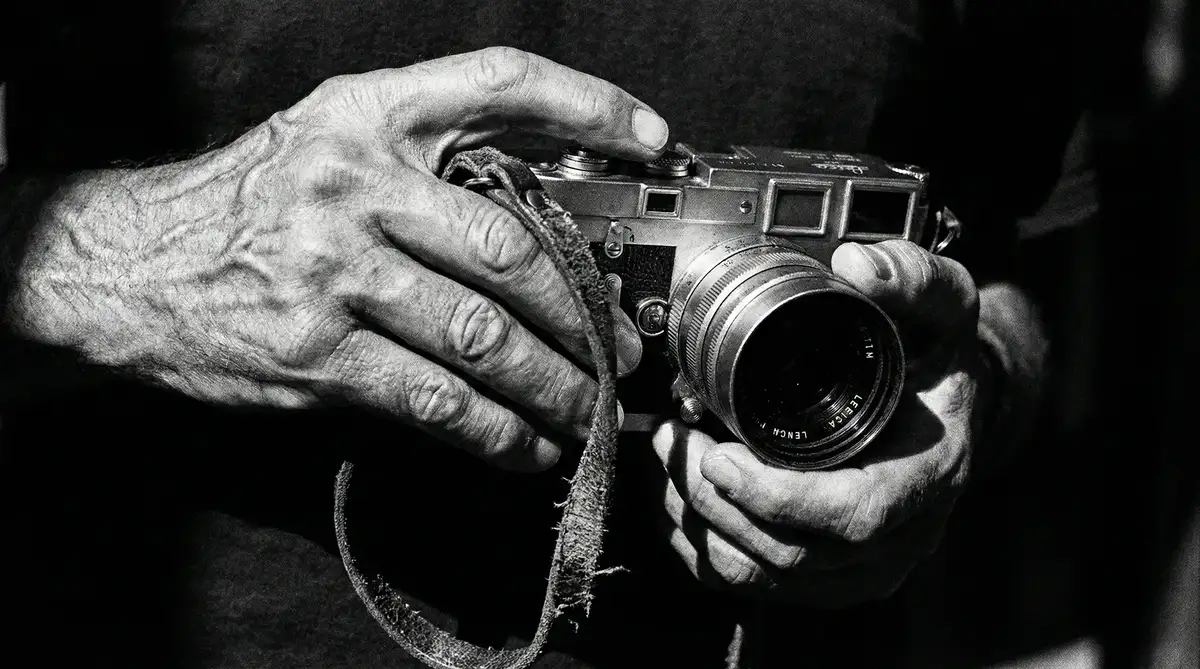 一双苍劲有力的手握持着胶片相机的特写纪实摄影
